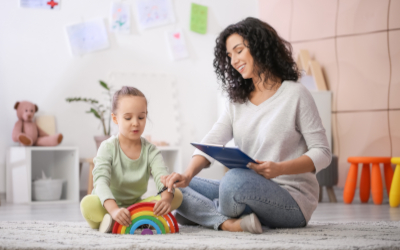Female psychologist working with little girl at home