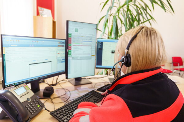 911 call center agent on the phone in front of computer.